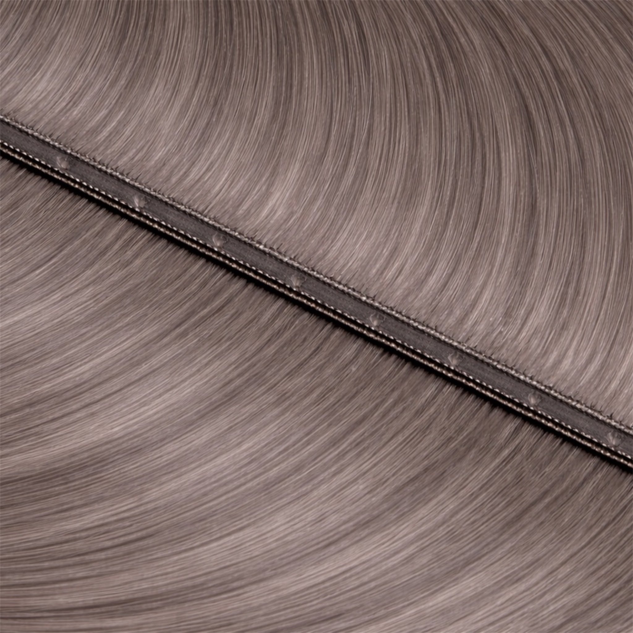 Close-up of ashy smokey blonde hair extensions with a seam with U Holes in the centre of the base.