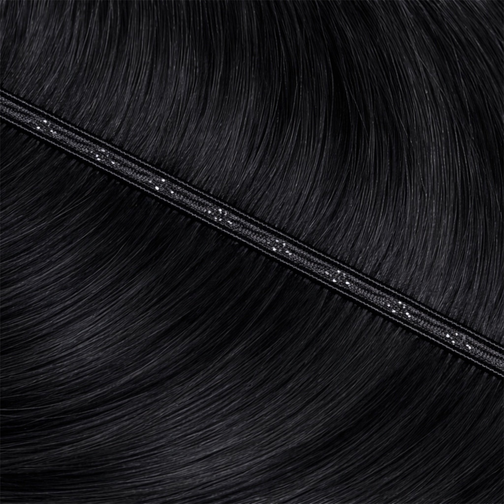 Close-up of black hair extensions with a black band